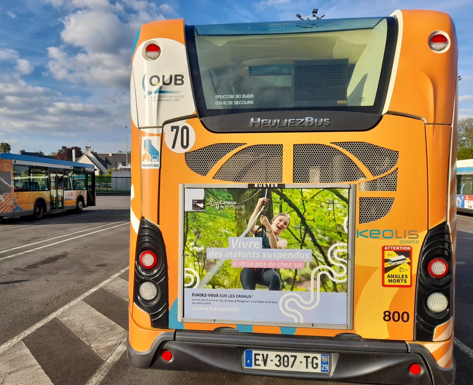 Affichage publicitaire pour les Canaux de Bretagne sur l’arrière d’un bus QUB à Quimper, captant l’attention aux intersections.